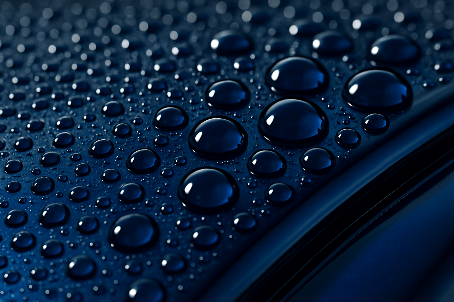 A dramatic close-up, macro photo of water beading perfectly into tight, spherical drops on the hood of a deep blue car. The paint is extremely glossy, demonstrating the hydrophobic effect of a ceramic sealant.