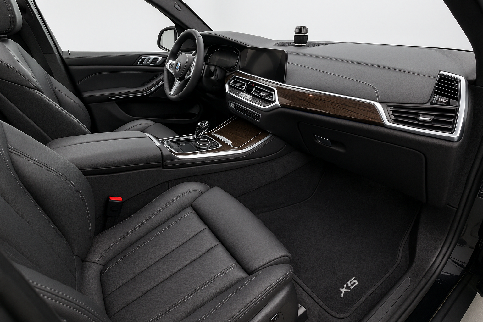 A wide interior shot of a luxury SUV (e.g., BMW X5) after a Signature Detail. The focus is on the impeccably vacuumed carpets and floor mats, with a clean and fresh appearance. A subtle, high-quality air freshener or scent dispenser is visible, adding to the sense of freshness.