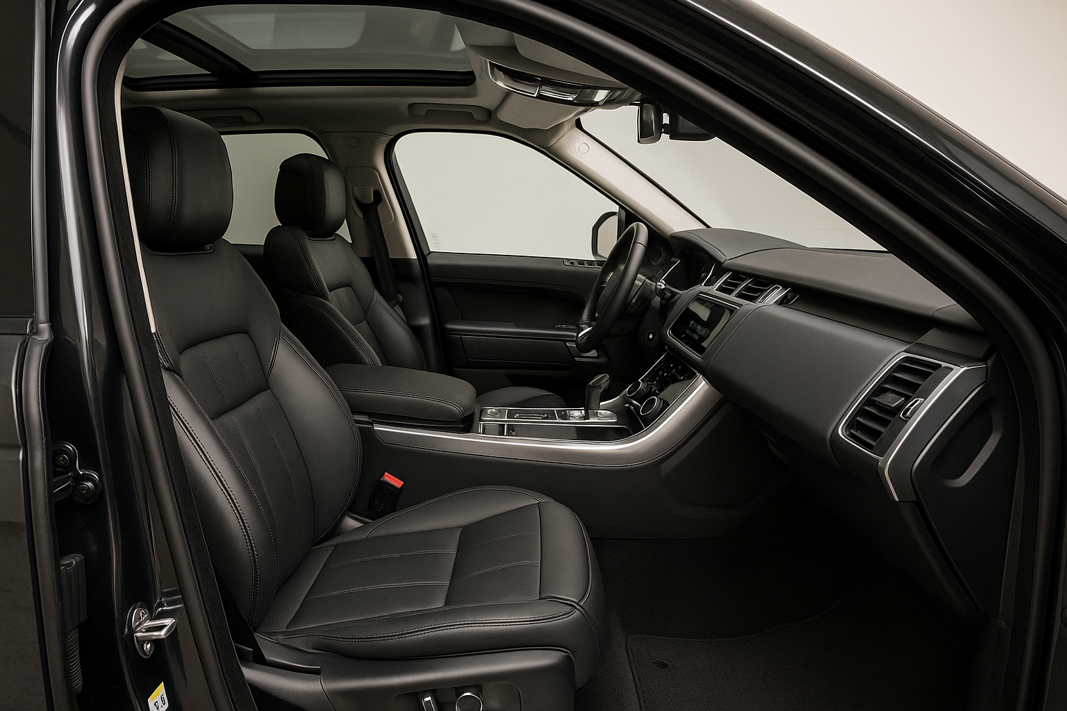 Ultra-realistic, professional photograph of the pristine interior of a modern luxury SUV, like a Range Rover or Porsche Cayenne. The shot is taken from the open passenger door, looking across the flawless black leather seats toward the clean, detailed dashboard. The lighting is soft and even, highlighting the textures of the leather, the clean carpets, and the dust-free console. The mood is luxurious, clean, and aspirational.
